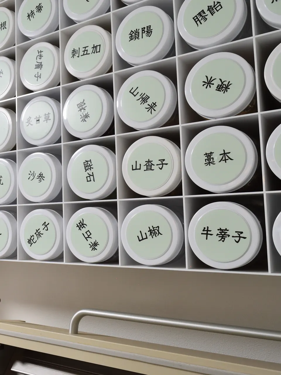 漢方薬局 下田康生堂の調剤室に並ぶ、生薬の保存容器