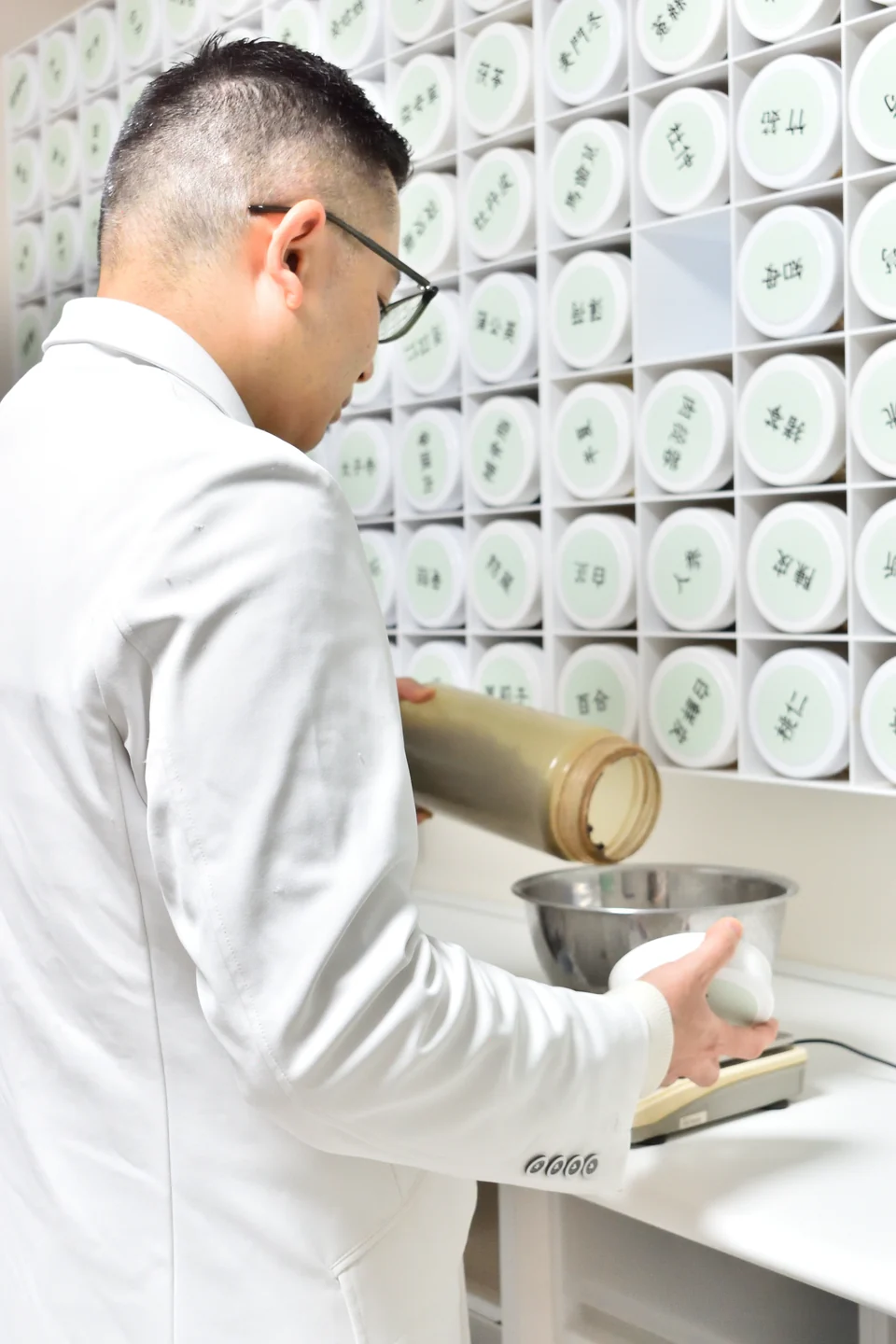 薬剤師が生薬を計量する様子